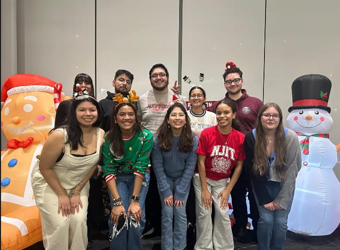 SAC members at a winter holiday event with inflatable snowman and gingerbread decorations