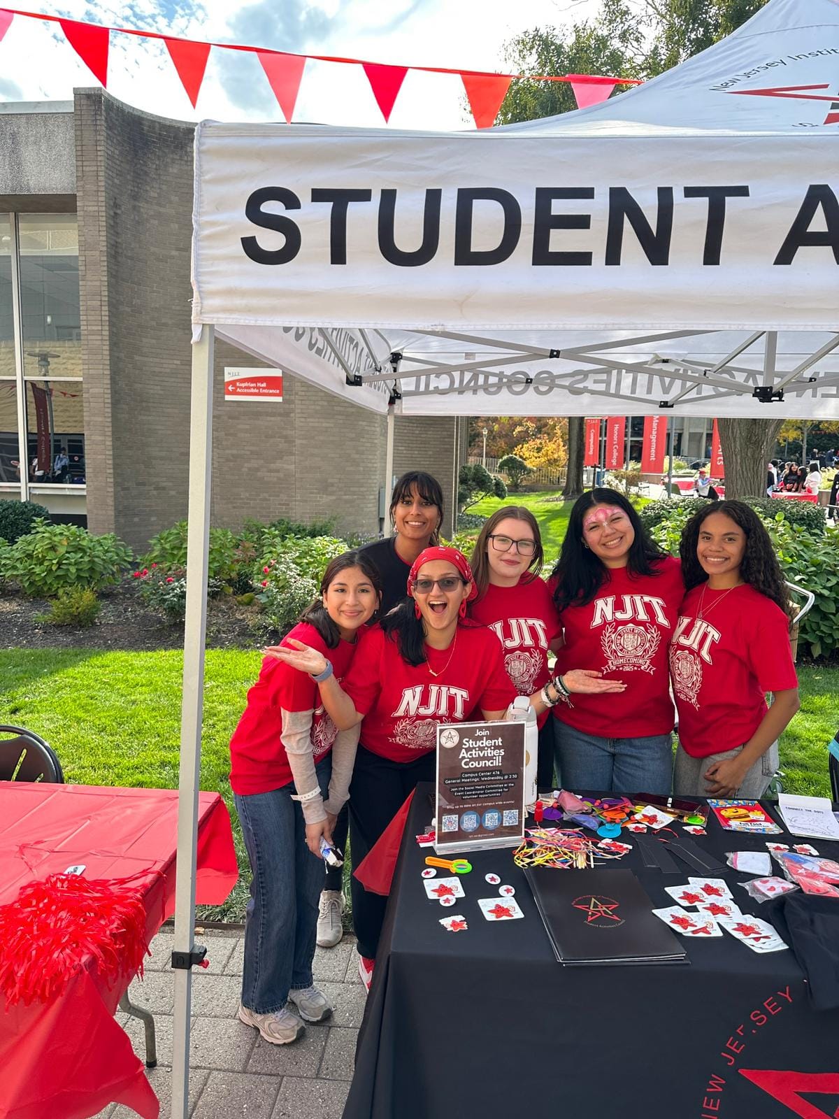 SAC members at their tabling booth on campus, wearing red NJIT shirts